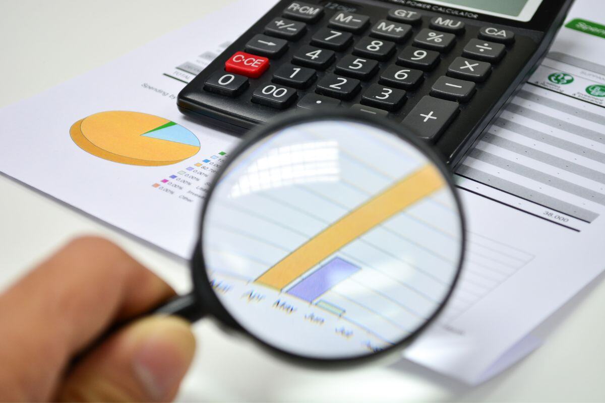 Report with calculator and magnifying glass representing digital analytics and ministry automation